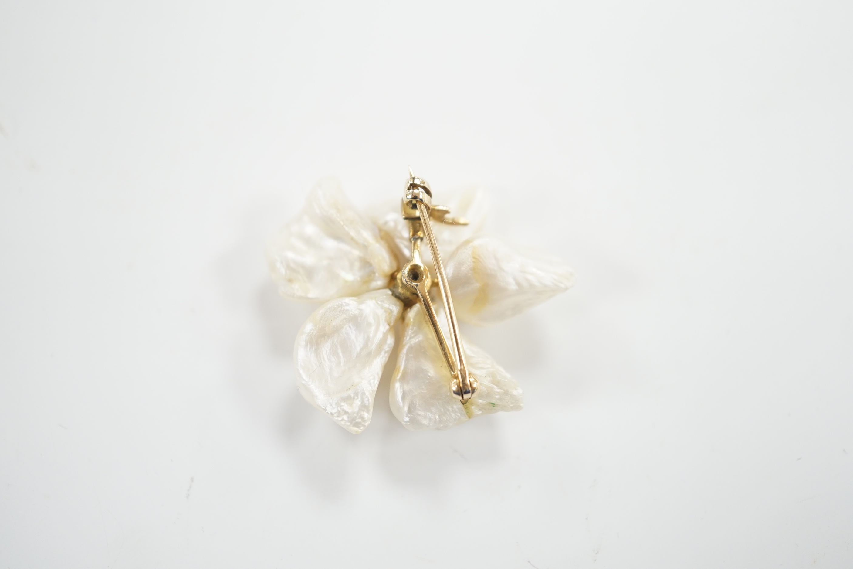 A yellow metal mounted baroque pearl and single stone diamond set flower head brooch, 30mm, gross weight 9.1 grams.